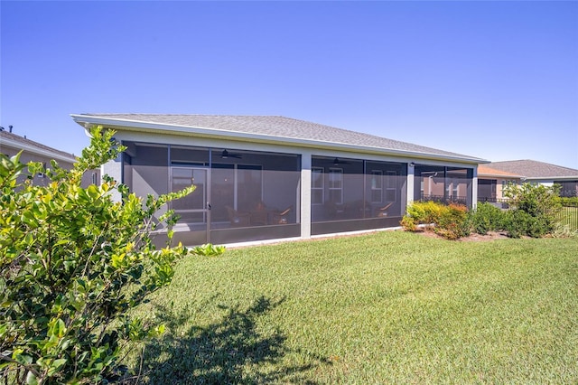 rear view of house with a lawn and a sunroom