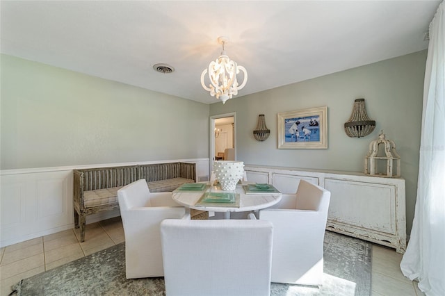 dining space with light tile patterned flooring and an inviting chandelier