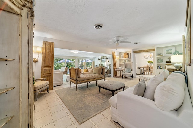 tiled living room featuring a textured ceiling and ceiling fan