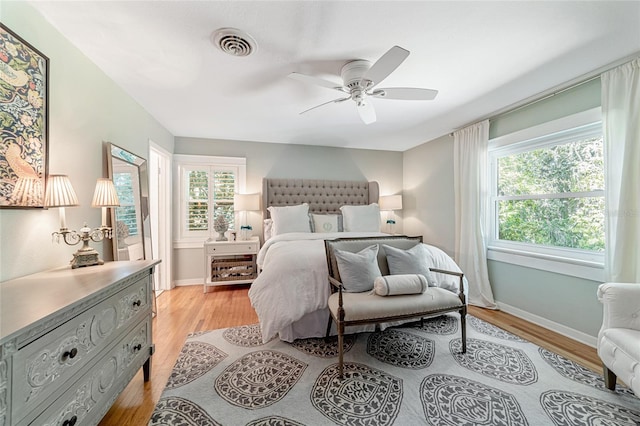 bedroom featuring light hardwood / wood-style floors, multiple windows, and ceiling fan