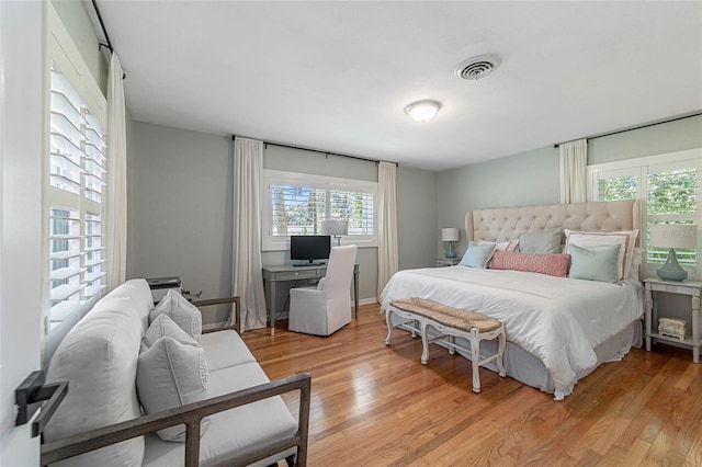 bedroom with light hardwood / wood-style floors and multiple windows