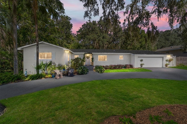 ranch-style home with a yard and a garage