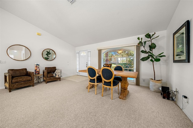 dining room with vaulted ceiling and carpet floors