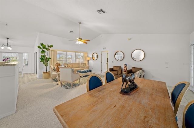 carpeted dining space featuring ceiling fan with notable chandelier and vaulted ceiling