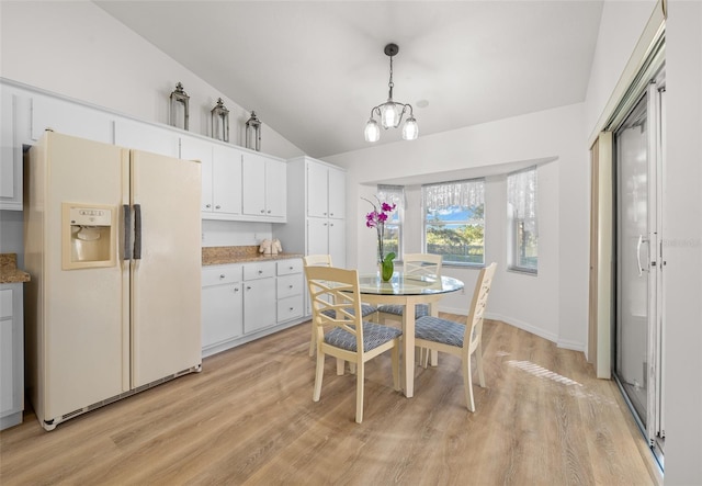 kitchen featuring lofted ceiling, white fridge with ice dispenser, white cabinetry, pendant lighting, and light hardwood / wood-style floors