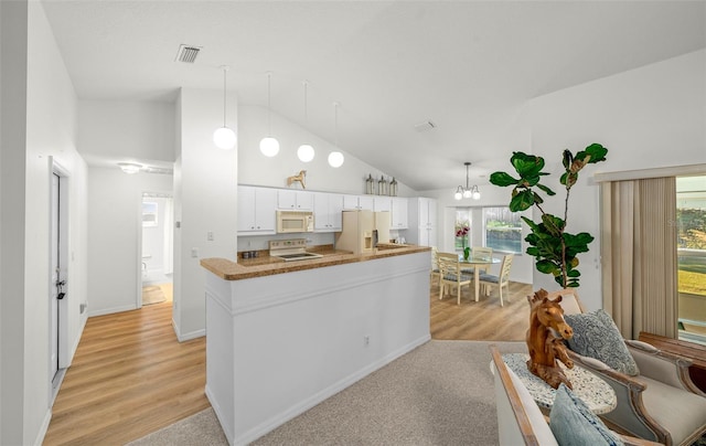 kitchen with white cabinetry, a wealth of natural light, high vaulted ceiling, and white appliances