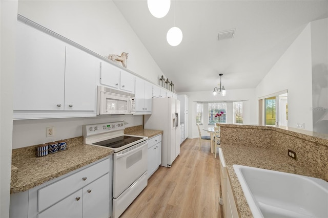 kitchen with white appliances, white cabinetry, vaulted ceiling, and hanging light fixtures