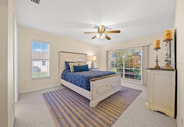 carpeted bedroom with ceiling fan and multiple windows