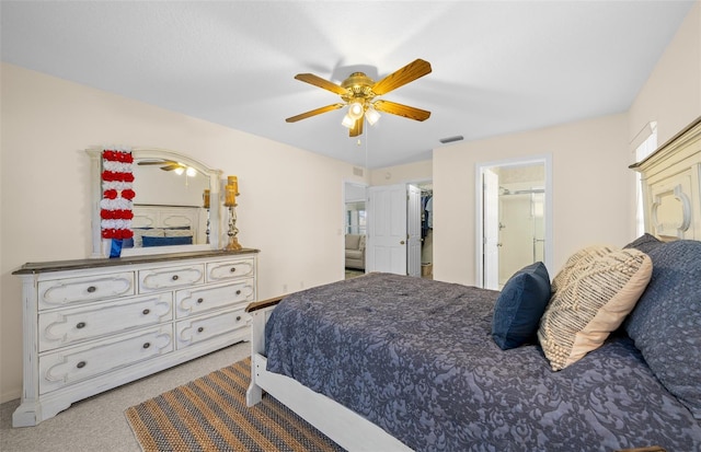 carpeted bedroom with a closet, ceiling fan, ensuite bath, and a walk in closet