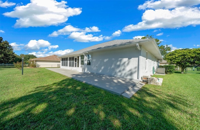 rear view of property with a yard, a patio area, and a sunroom