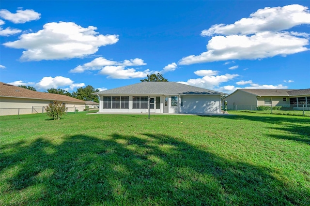 back of house featuring a sunroom and a lawn