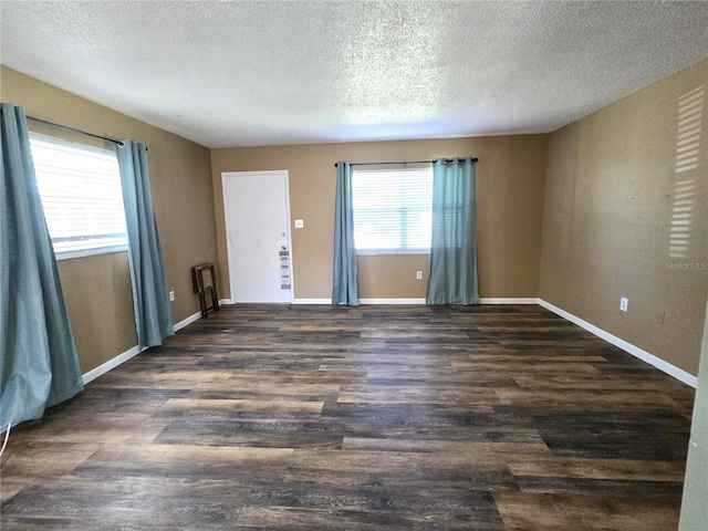 unfurnished room featuring a textured ceiling and dark hardwood / wood-style flooring