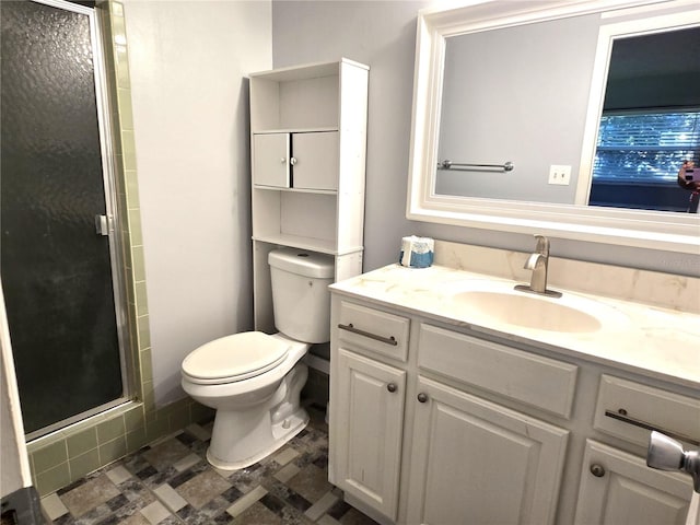 bathroom featuring vanity, toilet, and a shower with shower door