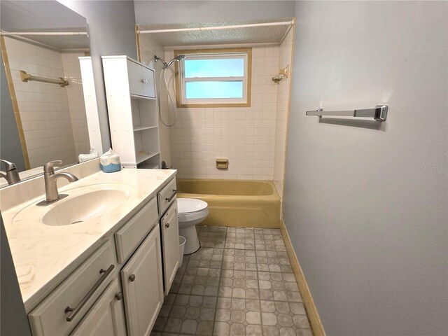 full bathroom featuring tiled shower / bath, vanity, toilet, and tile patterned flooring