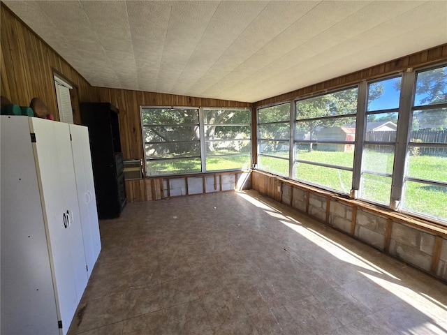 unfurnished sunroom featuring vaulted ceiling