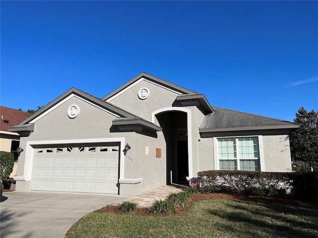 view of front of property featuring a front yard and a garage