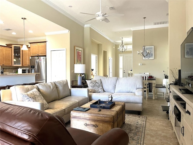 living room with a high ceiling, ornamental molding, light tile patterned flooring, and ceiling fan with notable chandelier