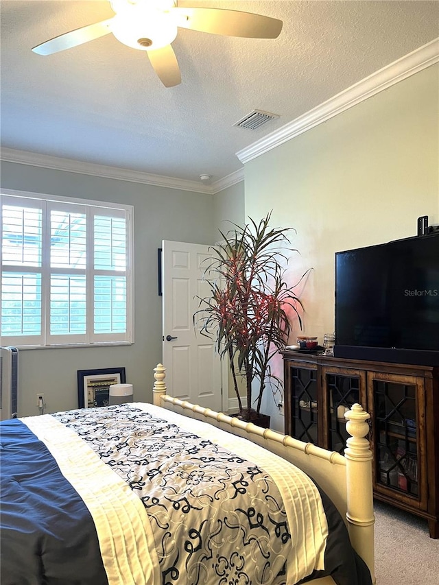 bedroom with crown molding, carpet flooring, a textured ceiling, and ceiling fan