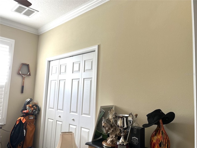 interior space with ornamental molding and a textured ceiling