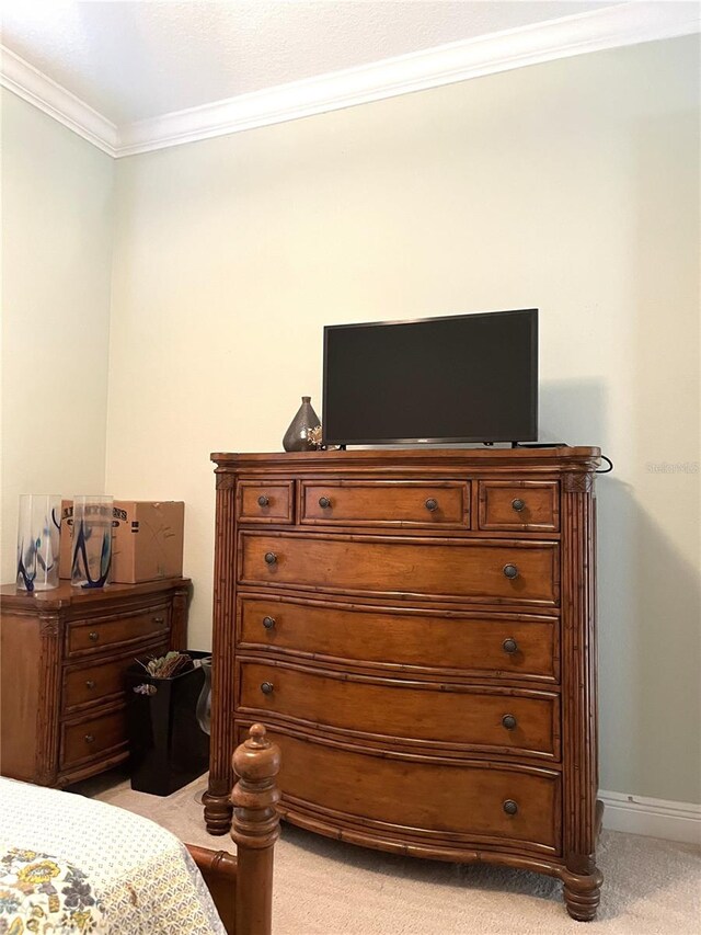 bedroom featuring crown molding and light carpet