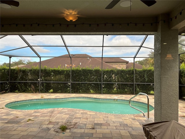 view of pool with ceiling fan, a lanai, and a patio area