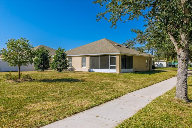 view of side of property featuring a lawn and a sunroom