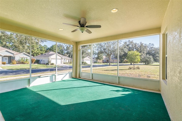 unfurnished sunroom with ceiling fan