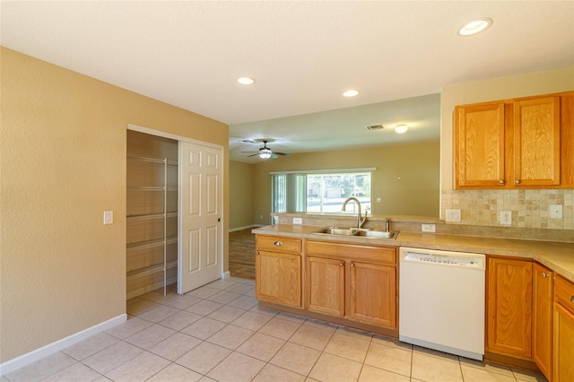 kitchen featuring light tile patterned flooring, backsplash, sink, and white dishwasher