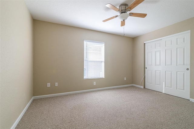 unfurnished bedroom with a closet, carpet, and ceiling fan