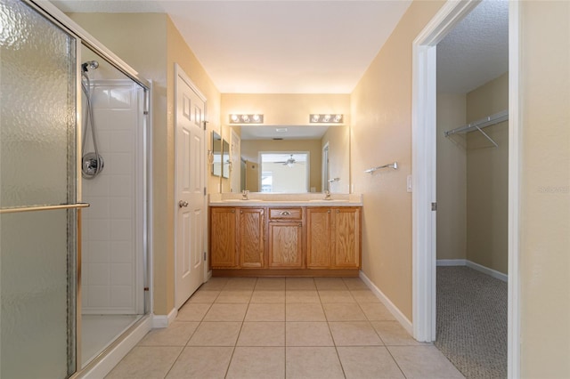 bathroom featuring vanity, a shower with shower door, and tile patterned floors