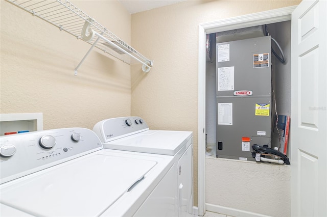 clothes washing area featuring washer and clothes dryer and heating unit