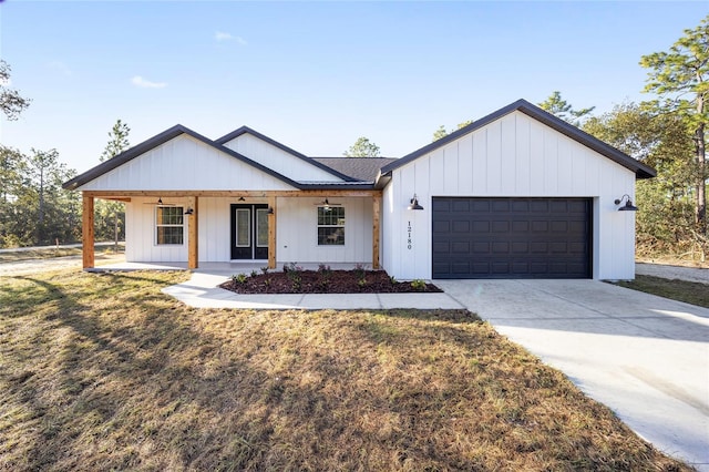 modern farmhouse style home with a front yard, a garage, and a porch