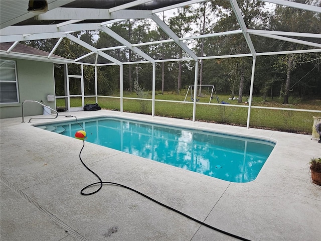 view of swimming pool with a patio area, a lanai, and a lawn