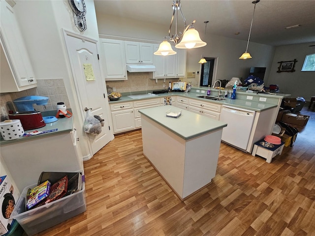 kitchen with white appliances, sink, a kitchen island, decorative light fixtures, and white cabinets