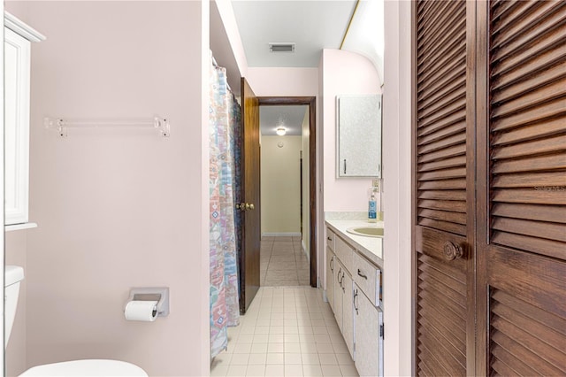 bathroom featuring tile patterned flooring, vanity, and toilet