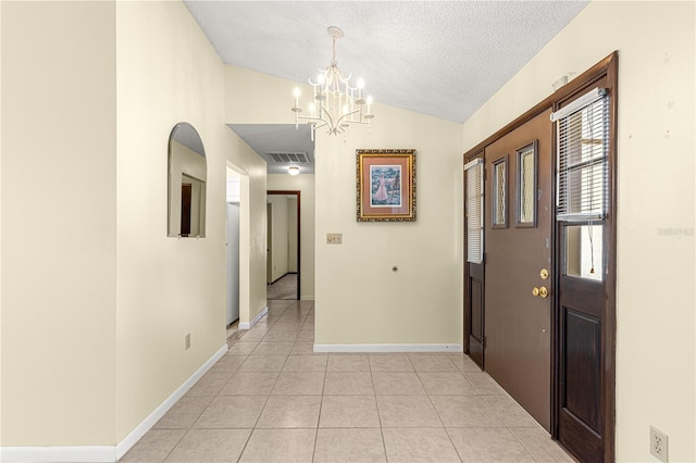 hall featuring a notable chandelier, vaulted ceiling, a textured ceiling, and light tile patterned floors