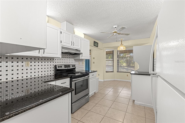 kitchen featuring stainless steel electric range oven, light tile patterned flooring, white cabinetry, dark stone countertops, and white refrigerator