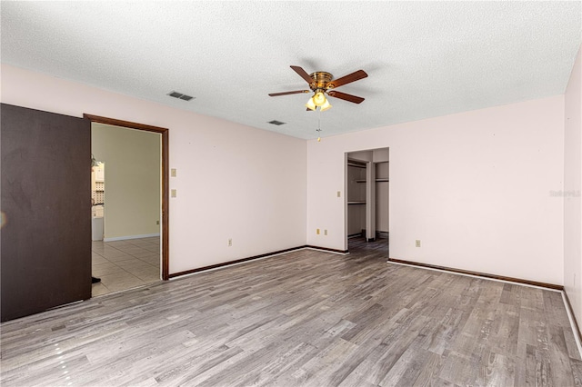 interior space featuring ceiling fan, a textured ceiling, and light wood-type flooring