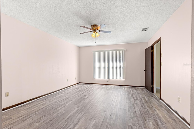 empty room featuring ceiling fan, light hardwood / wood-style floors, and a textured ceiling