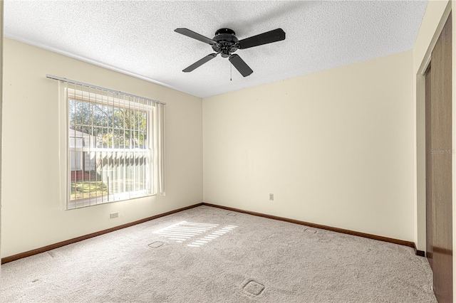 carpeted spare room featuring ceiling fan and a textured ceiling