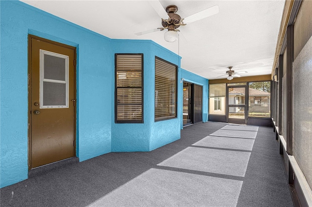 unfurnished sunroom featuring ceiling fan