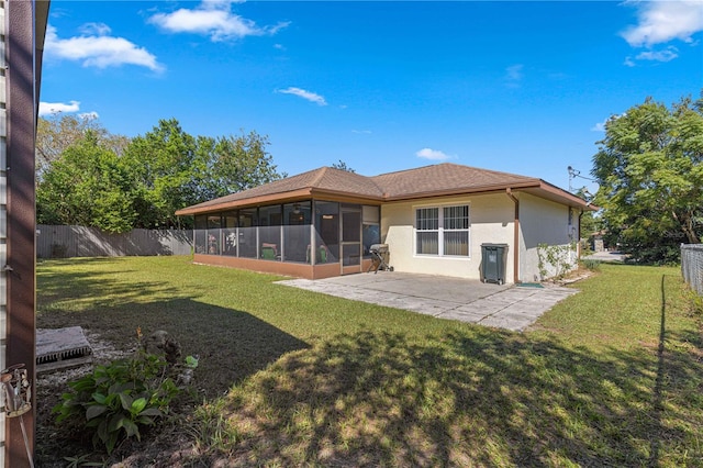 back of house with a yard, a sunroom, and a patio