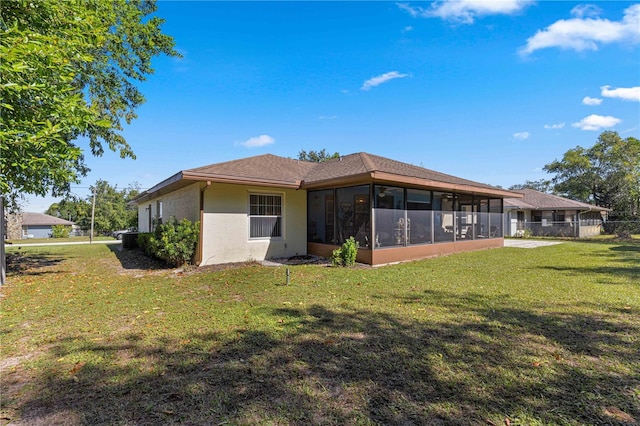 rear view of house with a sunroom and a yard