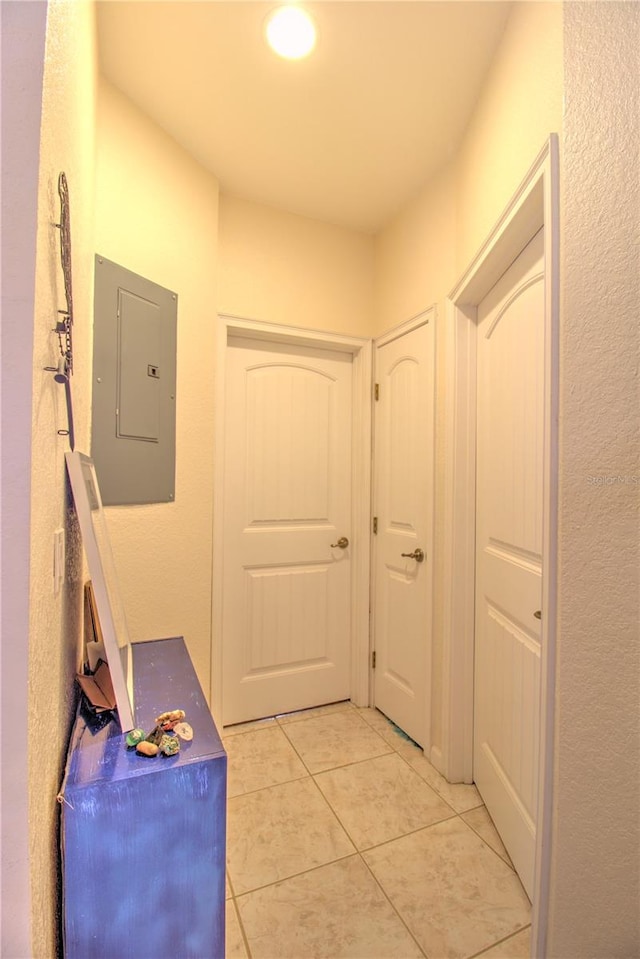 corridor featuring electric panel and light tile patterned floors