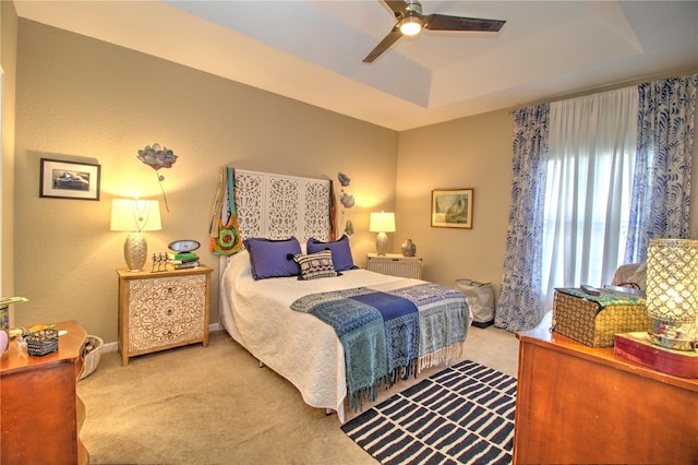 bedroom featuring a tray ceiling, ceiling fan, and carpet floors