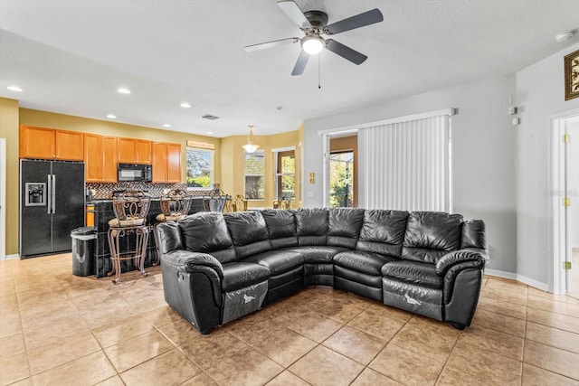 living room with light tile patterned floors, plenty of natural light, and ceiling fan