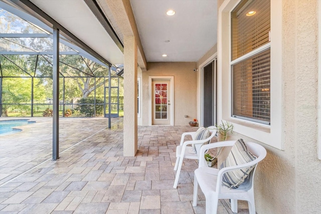 view of patio featuring glass enclosure