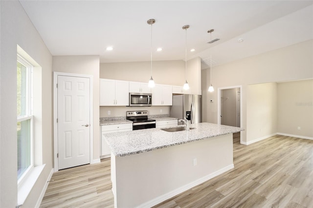 kitchen featuring lofted ceiling, an island with sink, hanging light fixtures, and stainless steel appliances