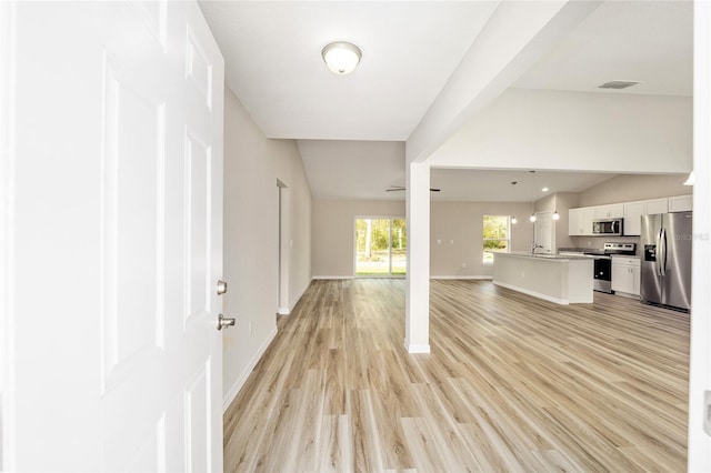 unfurnished living room featuring lofted ceiling and light hardwood / wood-style flooring