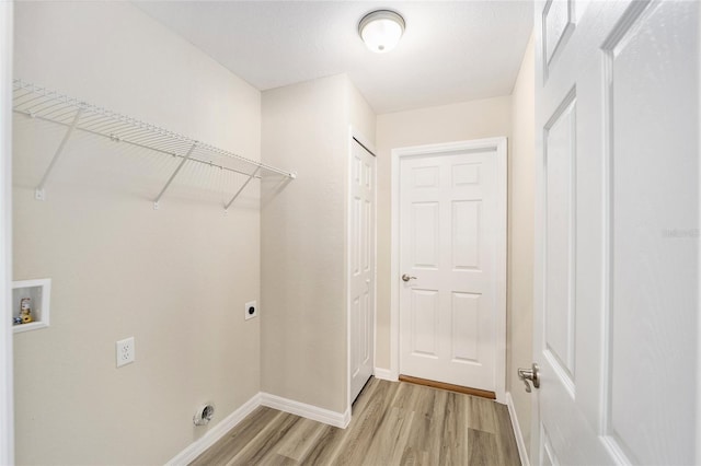 clothes washing area with hookup for an electric dryer, washer hookup, and light wood-type flooring